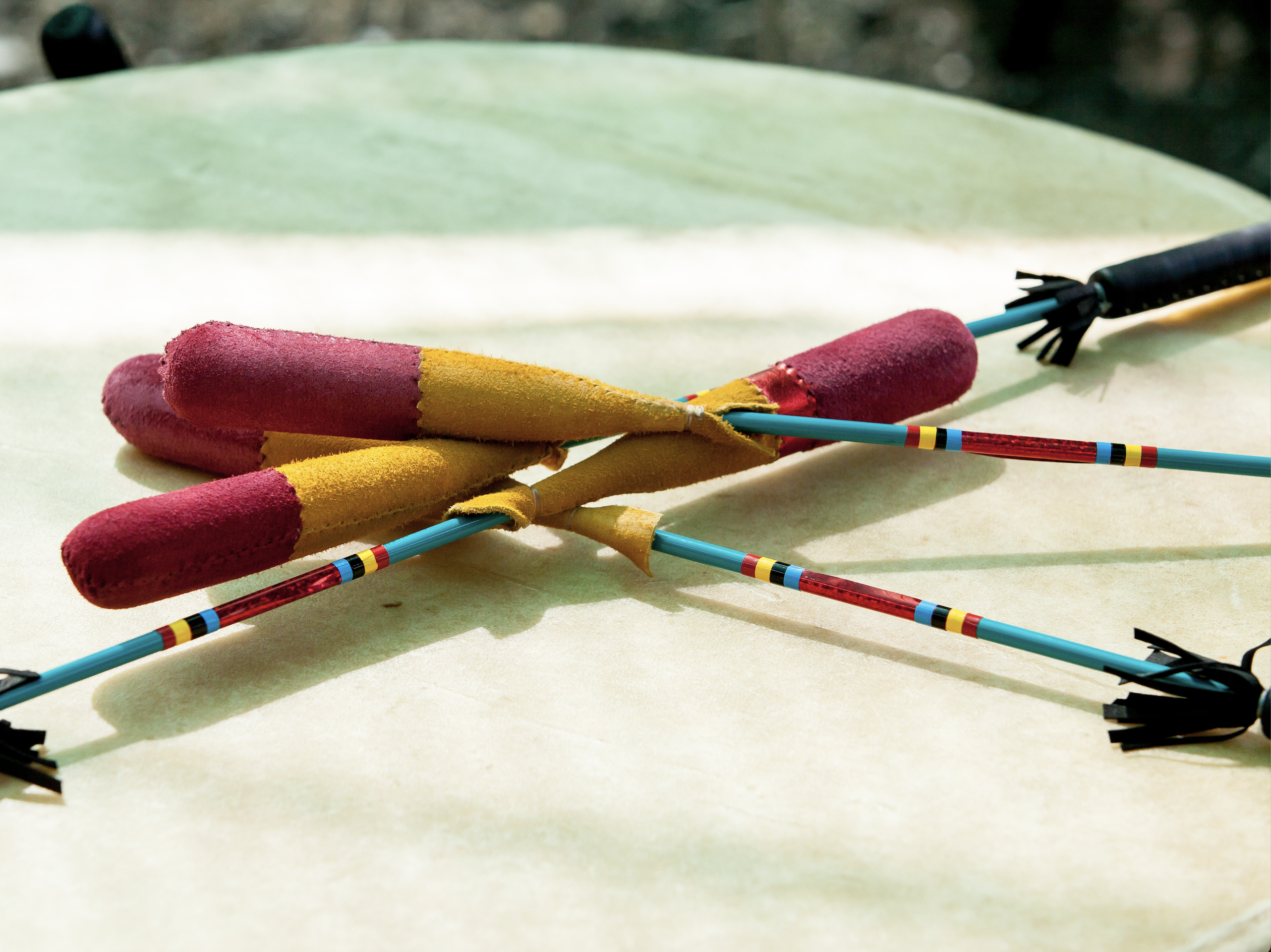 Photo of traditional drum sticks resting on pow wow drum