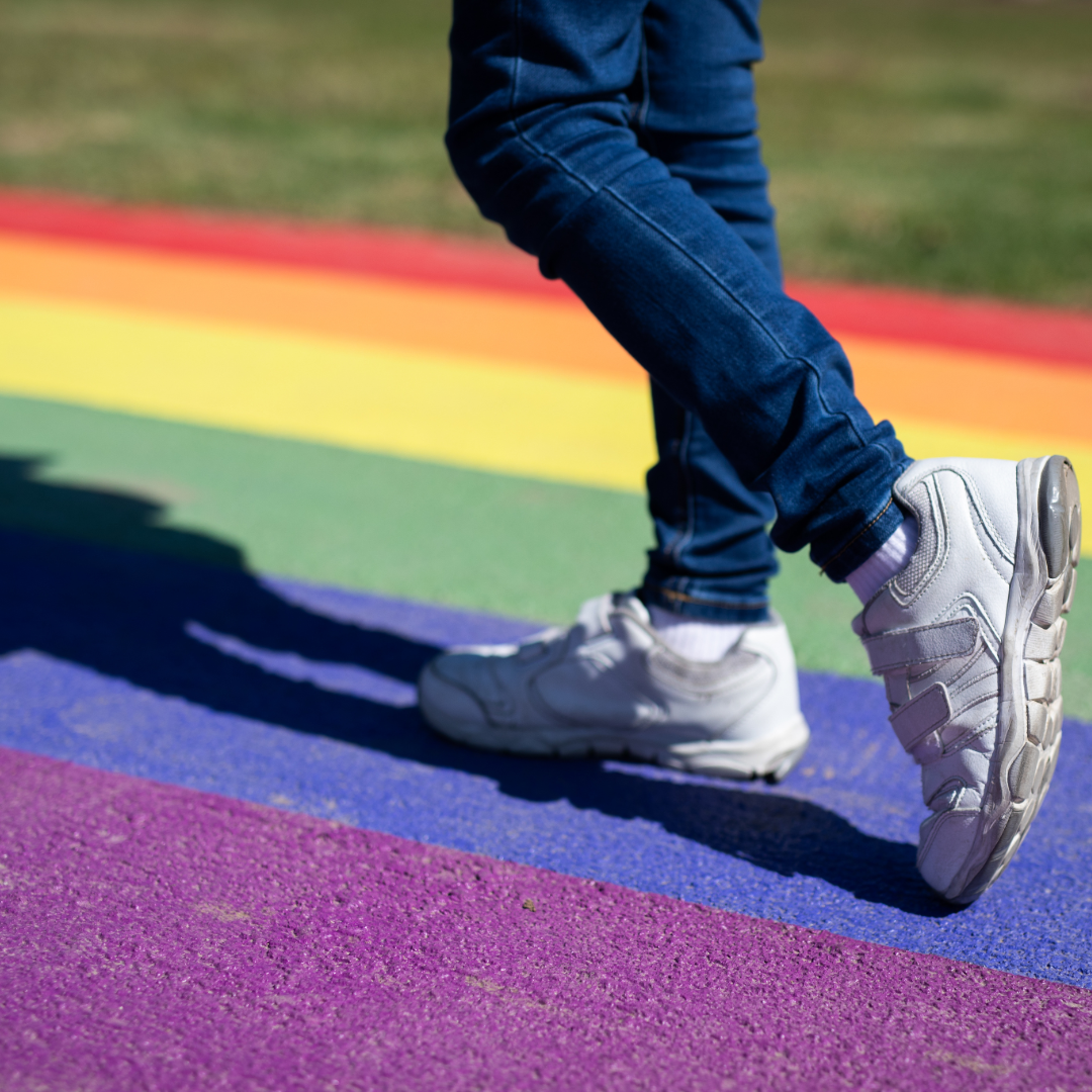 Image of person walking on rainbow colored street