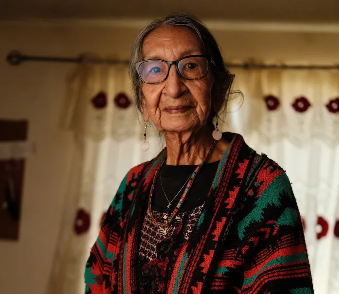 Portrait of Delphine Bad Wound wearing a shawl in a living room